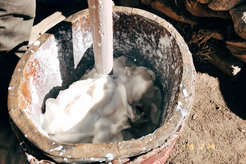 Tibetan pastoralist in a winter pasture churning yak milk to make butter and cheese